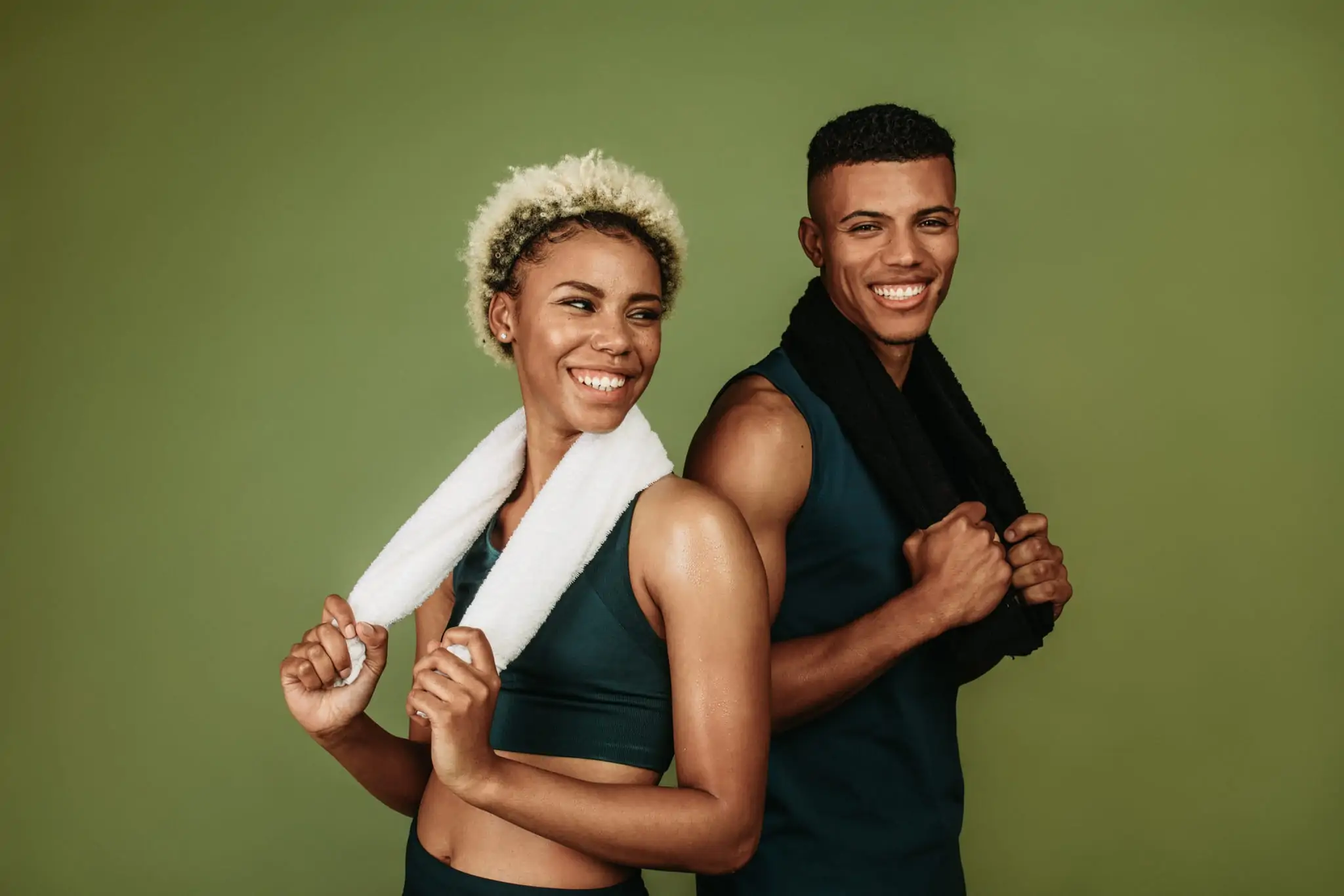 African American couple smiling and holding towels after a workout