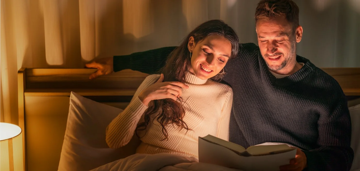 Couple reading in bed together at night