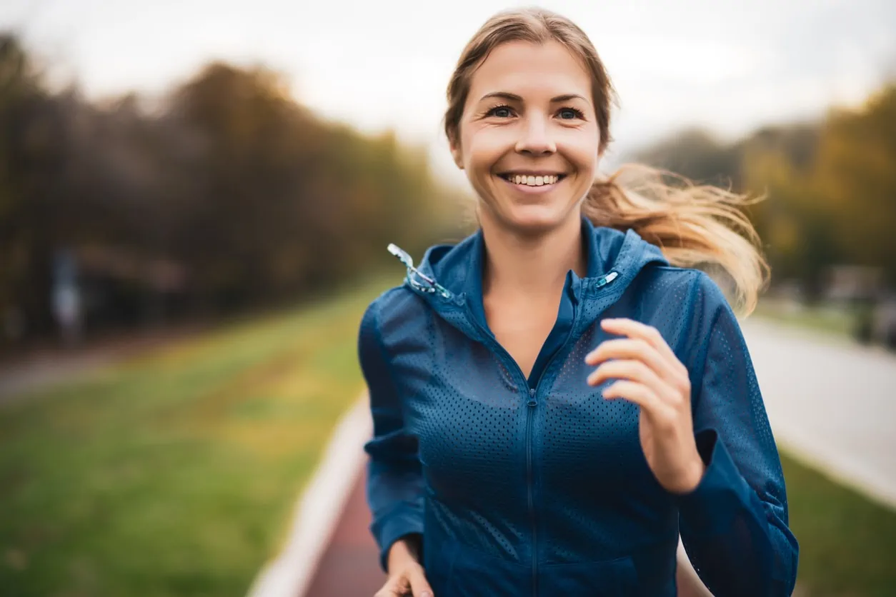Beautiful adult woman is jogging outdoors.