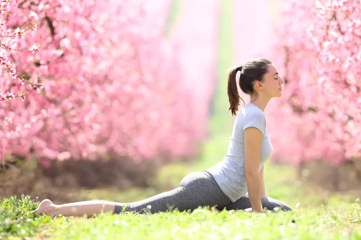 Profile of a yogi doing yoga exercise in a field during spring time