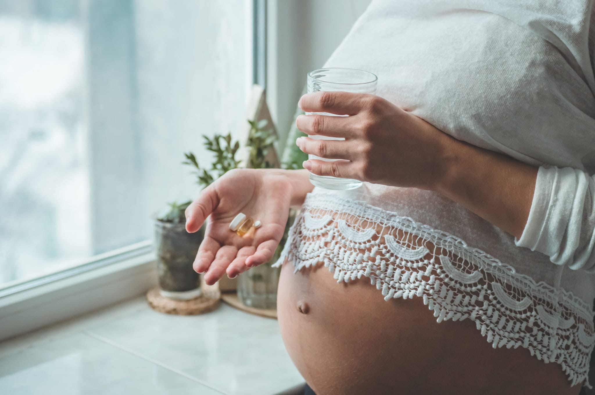 Pregnant woman taking pills during pregnancy. Last months of pregnancy.