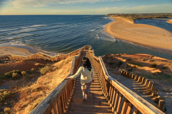 Woman walking down iconic Port Noarlunga boardwalk