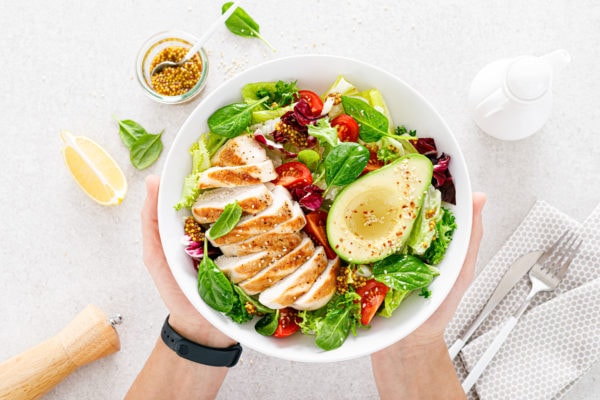 Grilled chicken and fresh vegetable salad of tomato, avocado, lettuce and spinach.