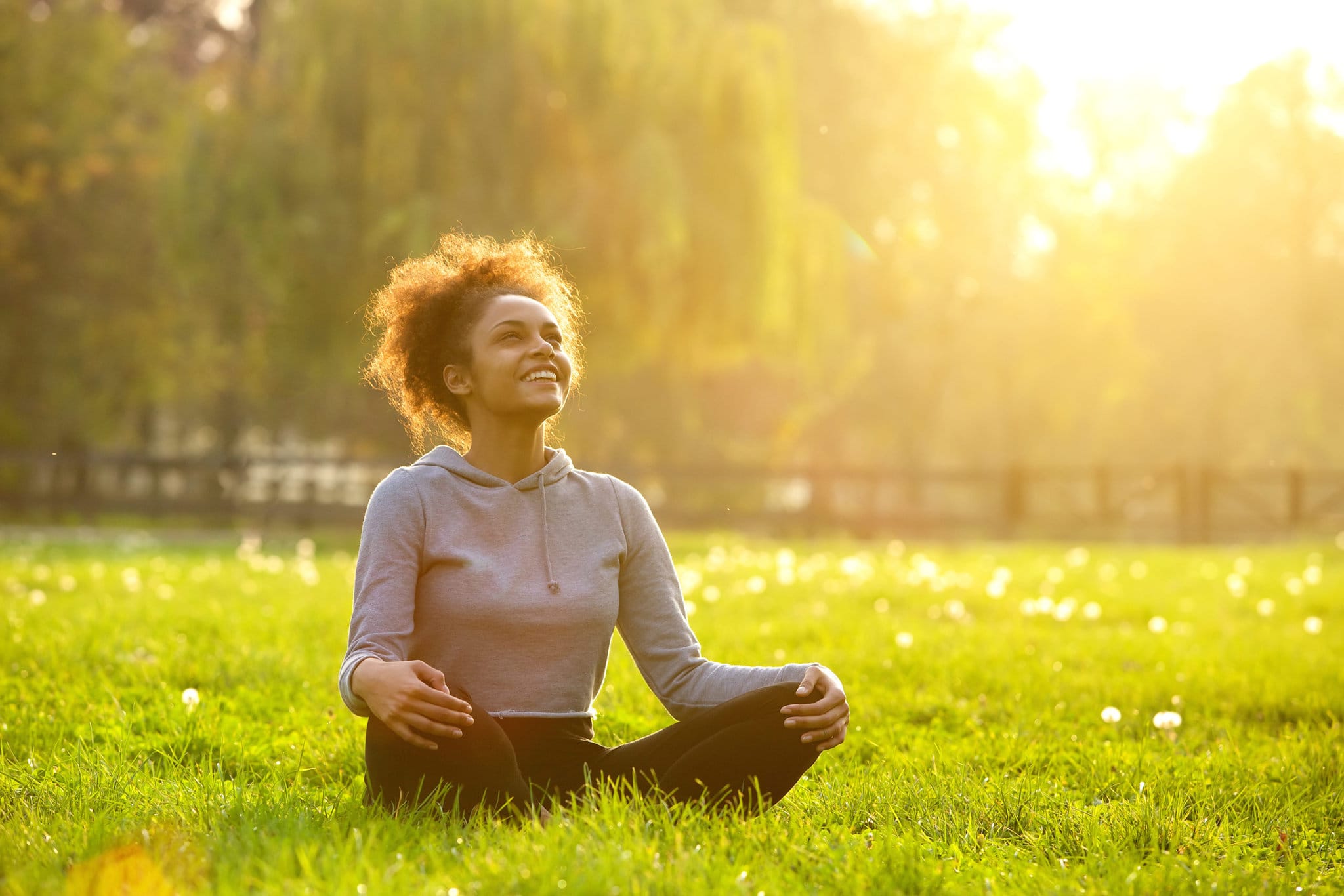 Happy young woman sitting in yoga position