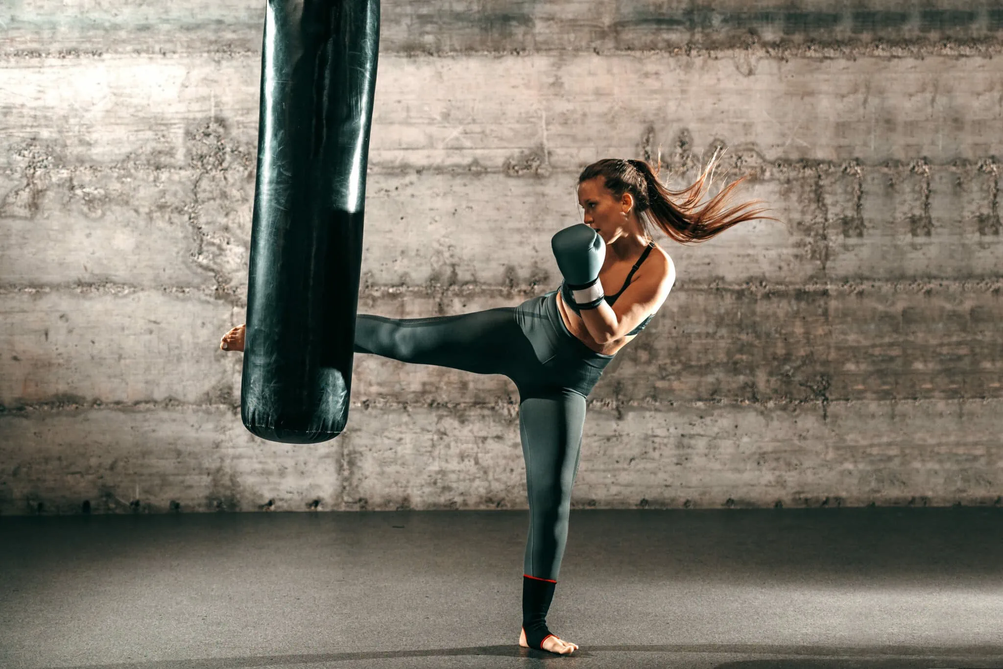 Young athletic woman kickboxing